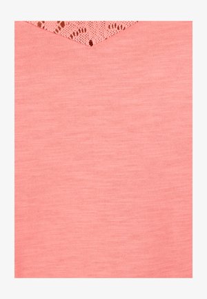 Tela rosa suave con textura de punto fino y un delicado detalle de encaje triangular en el borde superior.