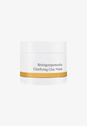 Bocal cylindrique blanc avec une bande dorée et une ligne grise. L'étiquette indique "Reinigungsmaske Clarifying Clay Mask" en texte noir.