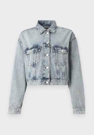 Šviesiai mėlynos denim tipo striukė, nukirpta ties liemeniu, su dviem krūtinės kišenėmis, sidabro spalvos mygtukais ir klasikiniu apykakle. Pasižymi nusidėvėjusiu tekstūros efektu ir ilgomis rankovėmis.