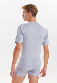 Grå bomulds t-shirt med korte ærmer og rund halsudskæring, parret med matchende korte trusser. Stof ser blødt og lidt strækbart ud.