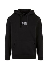Čierna mikina s kapucňou vyrobená z mäkkého materiálu, ktorá má predné klokanie vrecko a kapucňu so šnúrkami. Na hrudi je biele vyšívané logo "USA".