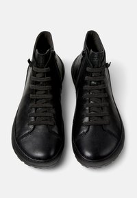 Pair of black leather high-top sneakers with textured surface, black laces, and side zippers, shown from above on white background.