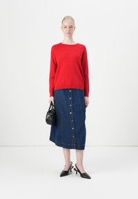 Red knitted sweater, denim button-up skirt, black handbag, and black slingback heels. Simple design with visible stitching and buttons.