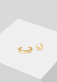 Goldfarbiger Metallring-Satz mit einem breiten Armreif mit strukturiertem Finish und einem kleineren, glatten Band. Beide Ringe sind offen gestaltet für eine individuelle Anpassung.