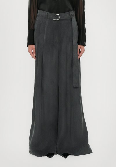Pantalones de pierna ancha en gris carbón, confeccionados en una tela suave, con una cintura alta, pasadores para cinturón y un detalle de hebilla plateada. Diseño con pliegues en la parte delantera.