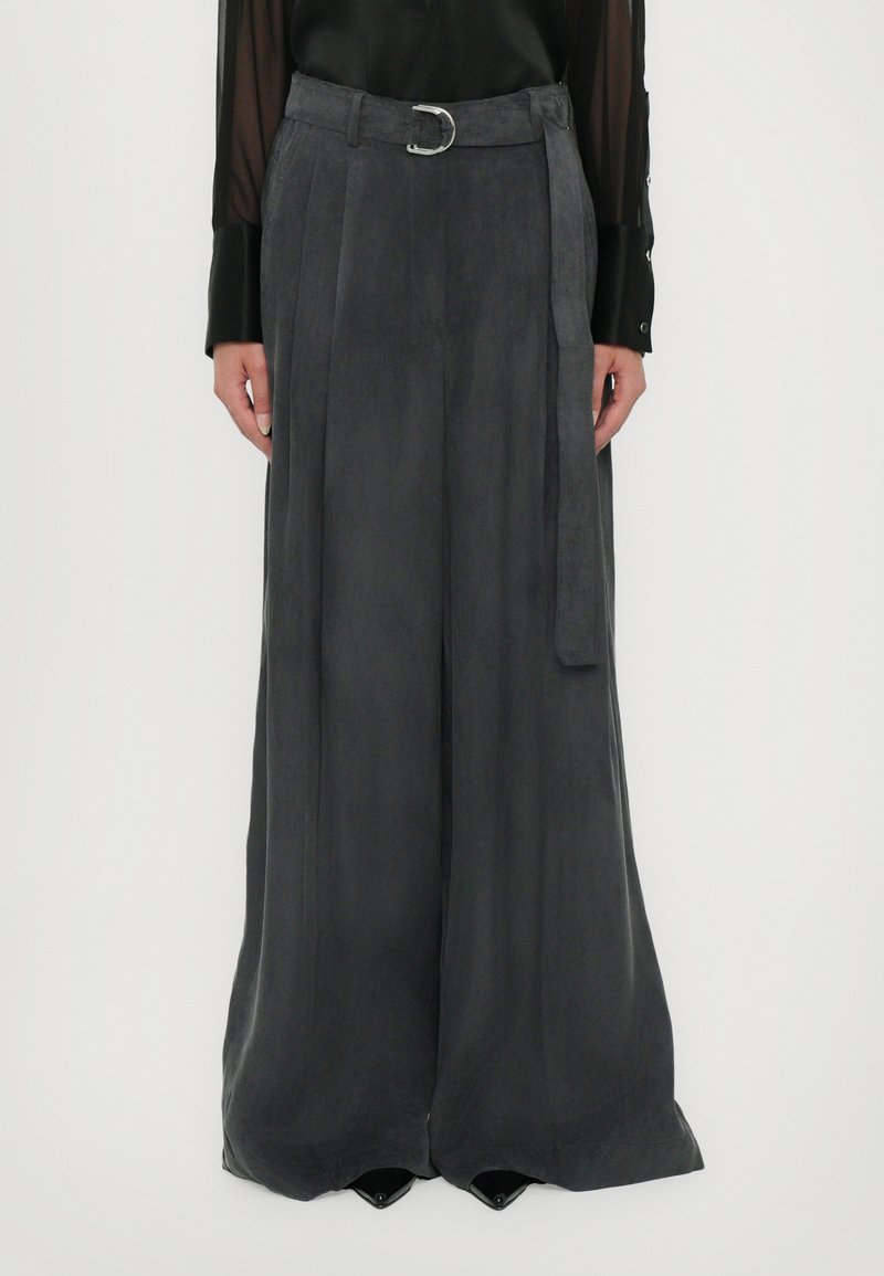 Pantaloni a gamba ampia grigio ardesia in tessuto morbido con una vita alta, passanti per cintura e un dettaglio in fibbia argentata. Design con pieghe frontali.