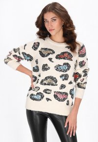 Sweter w kolorze kremowym z czarnymi, niebieskimi, koralowymi i złotymi cekinami w wzór lamparta. Miękka tekstura, okrągły dekolt i prążkowane mankiety.