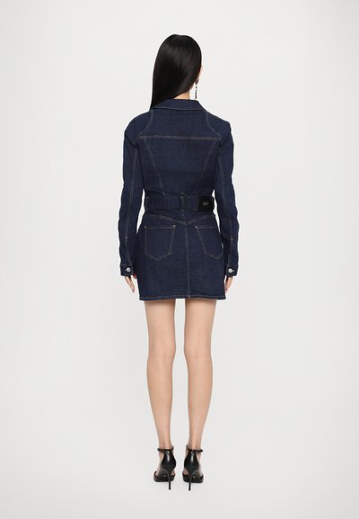 Denim dress with long sleeves, dark blue color, fitted design, belted waist, and two back pockets. Smooth texture with prominent stitching.
