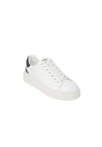 Zapatilla blanca de cuero con cierre de cordones, punta redonda y un acento en el talón texturizado en negro. Presenta ojales metálicos y una suela acolchada.