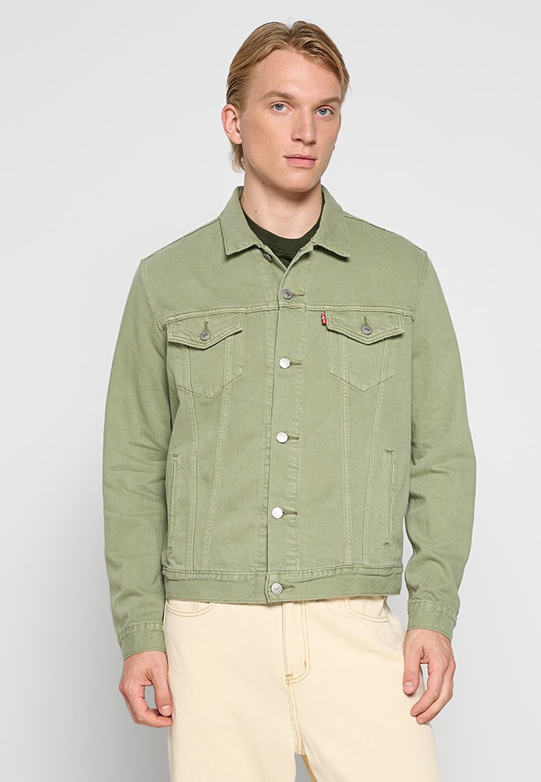 Giubbotto di denim verde chiaro con due tasche sul petto, bottoni a pressione argentati e un design strutturato. La trama del tessuto è leggermente a coste.