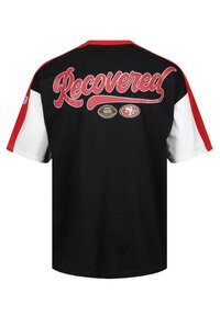 Sort T-shirt med røde og hvide korte ærmer. "Recovered" trykt i rødt med fodbolde og teamlogo detaljer nedenfor. Bomuldsstof.