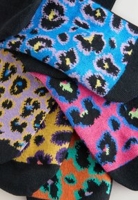 Färgglada strumpor med leopardmönster i nyanser av blått, rosa, lila, gult och orange med svarta detaljer; tillverkade av strukturerad stickad tyg.