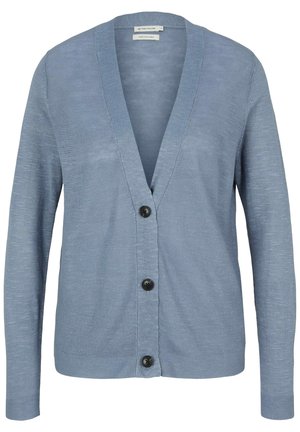 Vaaleansininen pitkähihaisen neuleen villatakki, jossa syvä V-kaula-aukko, kolme mustaa nappia ja lappu, jossa ilmoitetaan pellavakangas ja koko suuri.