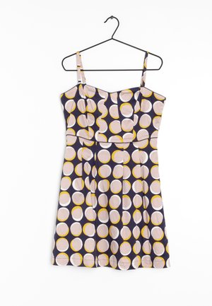 Sleeveless dress in dark purple fabric, featuring a pattern of large pink, white, and yellow circles. Includes a fitted bodice and pleated skirt.