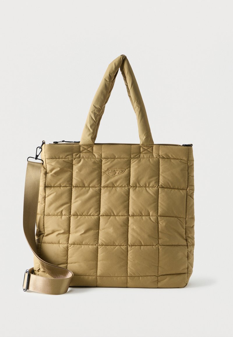 Καπιτονέ τσάντα tote σε ταμπά χρώμα με επενδυμένες χειρολαβές και ρυθμιζόμενο ιμάντα ώμου σε απλό λευκό φόντο.