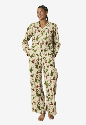 Pyjamaset gjort av lätt tyg med en krämfärgad bakgrund, med ett festligt mönster av gröna Grinch-karaktärer och julkransar.