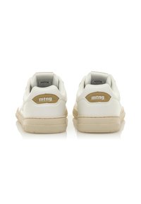 Zapatillas de cuero blancas con acentos beige, con punta redondeada, cuello acolchado y detalle del logo en el talón. Suela plana de goma.