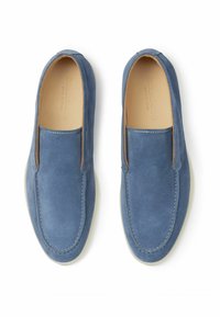 Zapatos azul de ante sin cordones con suelas blancas, que presentan una textura suave y costuras simples a lo largo de los bordes para un diseño limpio.
