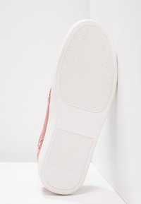Rosa canvas sneakers med en texturerad tygöverdel och en vit gummisula med ett vågigt mönster för bra grepp.