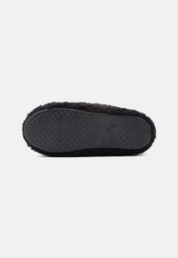 Črne copate z teksturirano gumijasto podplatom, ki ima majhne krožne vzorce. Zgornji del je mehak in puhast, kar daje prijeten videz.