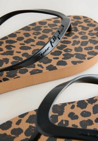 Crne japanke s leopard uzorkom na ulošku, s teksturiranom smeškom sole od smešane gume, i glatkim crnim trakama. Sadrži reljefni logotip na traci.