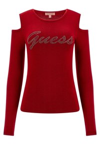 Haut rouge à manches longues avec épaules dénudées, orné du logo "Guess" en strass sur la poitrine, col rond et silhouette ajustée.