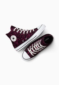 Baskets montantes et basses au design léopard violet, avec des lacets blancs, des semelles en caoutchouc et un patch logo circulaire sur le côté.