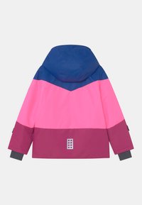 Bunte, wasserdichte Jacke mit einer blauen Kapuze, farblich abgesetztem Design in Pink und Burgund und einem silbernen Logodetail an der unteren Rückseite.