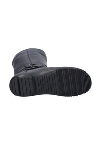 Bottine en cuir noir avec une surface lisse, un détail de boucle sur le côté et une semelle en caoutchouc texturée avec des motifs de crampons définis.
