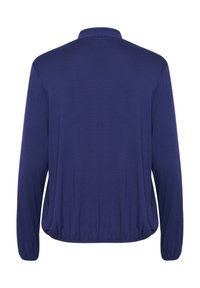 Top a maniche lunghe blu navy con colletto alto, orlo elastico e texture liscia senza motivi o chiusure visibili.