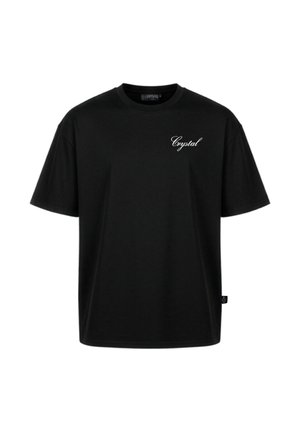 T-shirt noir à manches courtes avec texte blanc en cursive « Crystal » sur la poitrine gauche et une petite étiquette noire sur la couture latérale droite.