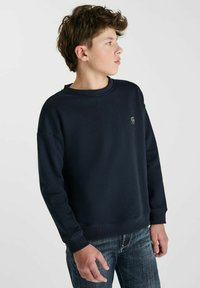 Marineblauwe crewneck sweatshirt van zacht materiaal, met ribgebreide manchetten en zoom, en een klein logo aan de rechter voorkant.