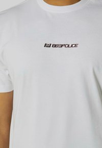 White cotton t-shirt featuring a bold black "883POLICE" logo in an angled design on the chest. Short sleeves and crew neckline.