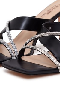 Sandales à talons noires avec des brides croisées ornées d'accents en strass argentés, design à bout carré et finition mate lisse.