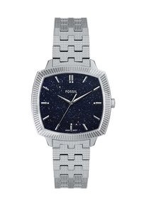 Montre avec un cadran carré argenté et un fond étoilé bleu foncé, des index horaires argentés et un bracelet en maille argentée texturée. Comprend un logo et un mouvement japonais.
