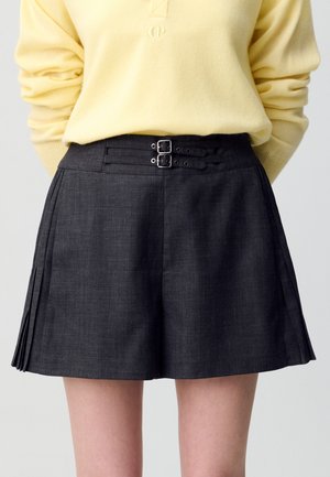 Gonna plissettata grigio scuro realizzata in tessuto testurizzato, con una vita dotata di doppia fibbia per una vestibilità regolabile.
