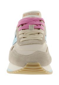 Vooraanzicht van een beige sneaker met lichtblauwe zijkantdetail, roze en beige veters, en een "victoria" label op de tong.