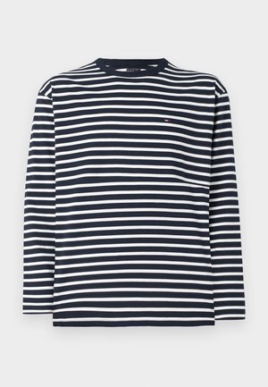 Tumesinine ja valge triibuline pikakä sleeves t-särk ümmarguse kaelusega ja väikese logo detailiga rinnal. Puuvillane kangas sileda tekstuuriga.