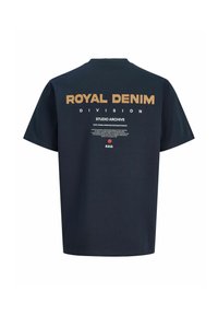 Schwarzes T-Shirt mit großem beigem Schriftzug "ROYAL DENIM" und kleineren weißen Schriftzügen "DIVISION" und "STUDIO ARCHIVE" auf der Rückseite.