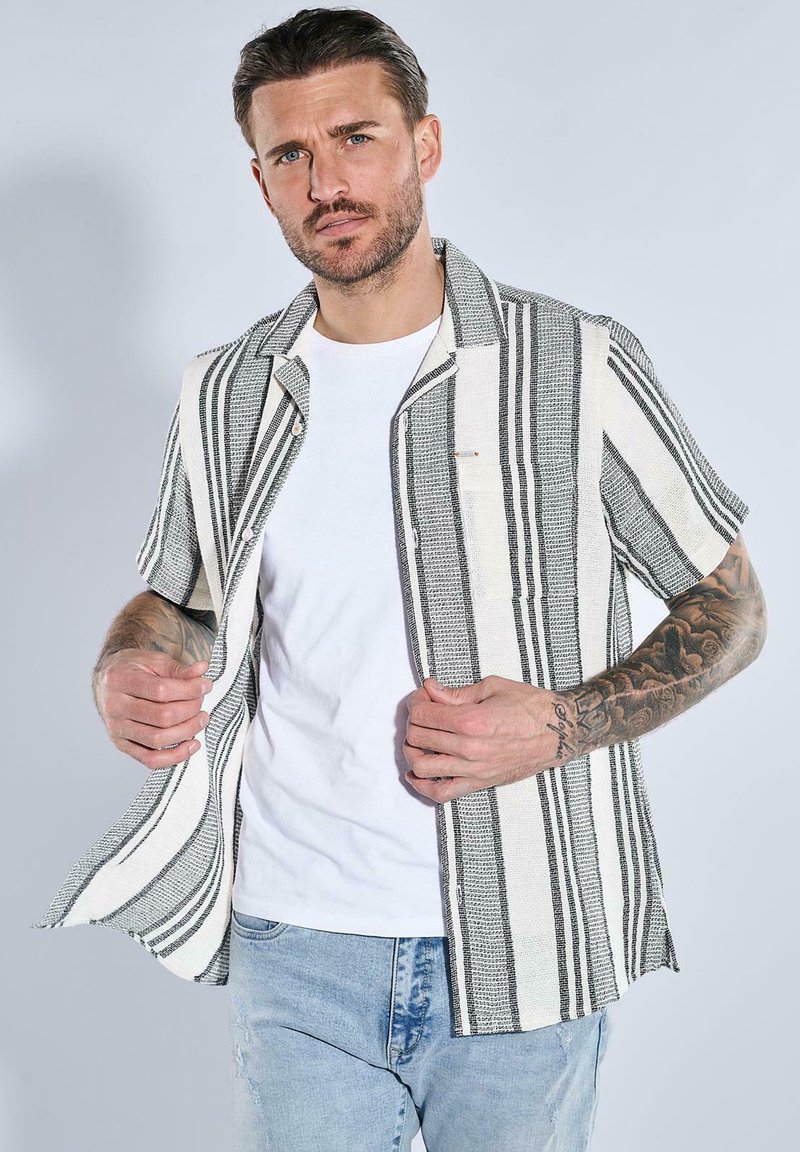 Kurzärmeliges, knöpfbares Hemd aus schwarz-weiß gestreiftem Stoff mit strukturiertem Gewebe. Verfügt über eine Brusttasche und einen regulären Schnitt.