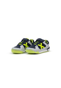 Zapatillas con una parte superior sintética en gris y azul marino, acentos en amarillo neón, paneles de malla texturizada y cordones negros. Incluye una correa ajustable.