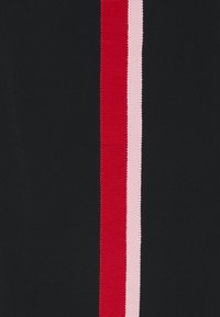 Czarna tkanina z trzema pionowymi paskami: jednym czerwonym, jednym różowym i jednym jasnoróżowym. Paski są wąskie i mają teksturowany wygląd.