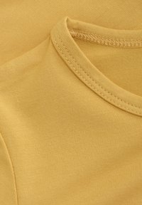 Ärmlös gul bomulls-t-shirt med ribbat mönster och rund halsringning, med en slät yta och subtila sömnadsdetaljer.