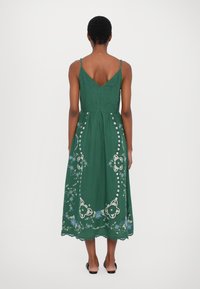 Zelené midi šaty s vyšívanými květinovými vzory, nastavitelné ramínka a designem do V na zadní straně. Lehky materiál s volným siluetem.