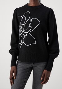 Schwarzer Strickpullover mit weißem floralen Konturdesign, runden Ausschnitt und gerippten Bündchen und Saum. Weiche Textur mit gepuffter Schulterdetail.