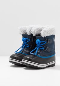 Stivali invernali impermeabili neri e blu. Presentano un morbido rivestimento grigio, dettagli blu, lacci regolabili e suola in gomma testurizzata.