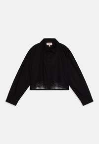 Blouse noire courte avec des manches longues, un col pointu, une fermeture à boutons sur le devant et un motif à pois décoratif à l'ourlet.
