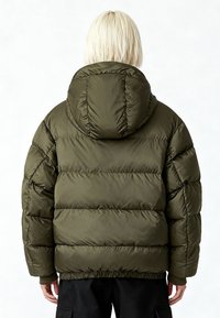 Doudoune vert olive à capuche, avec sections matelassées et poignets élastiques. Le tissu a une texture lisse et une finition légèrement brillante.