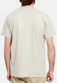 T-shirt in cotone grigio chiaro con maniche corte. Design semplice, colletto rotondo e texture liscia. Nessuna trama o decorazione visibile.