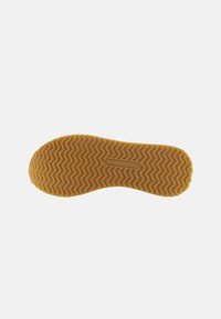 Rubber shoe sole in yellow with a wavy tread pattern, featuring a rectangular accent with "U.S. POLO ASSN" embossed.